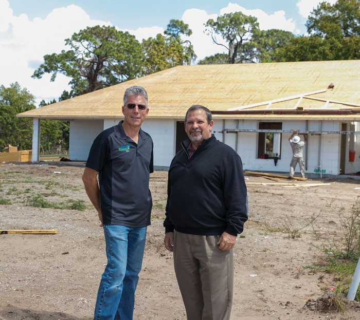 Florida Home Partnership's Construction Manager, Jody Fitzgerald and Executive Director, Mike Morina in front of one of seven Net Zero Energy Homes being constructed in Ruskin, FL